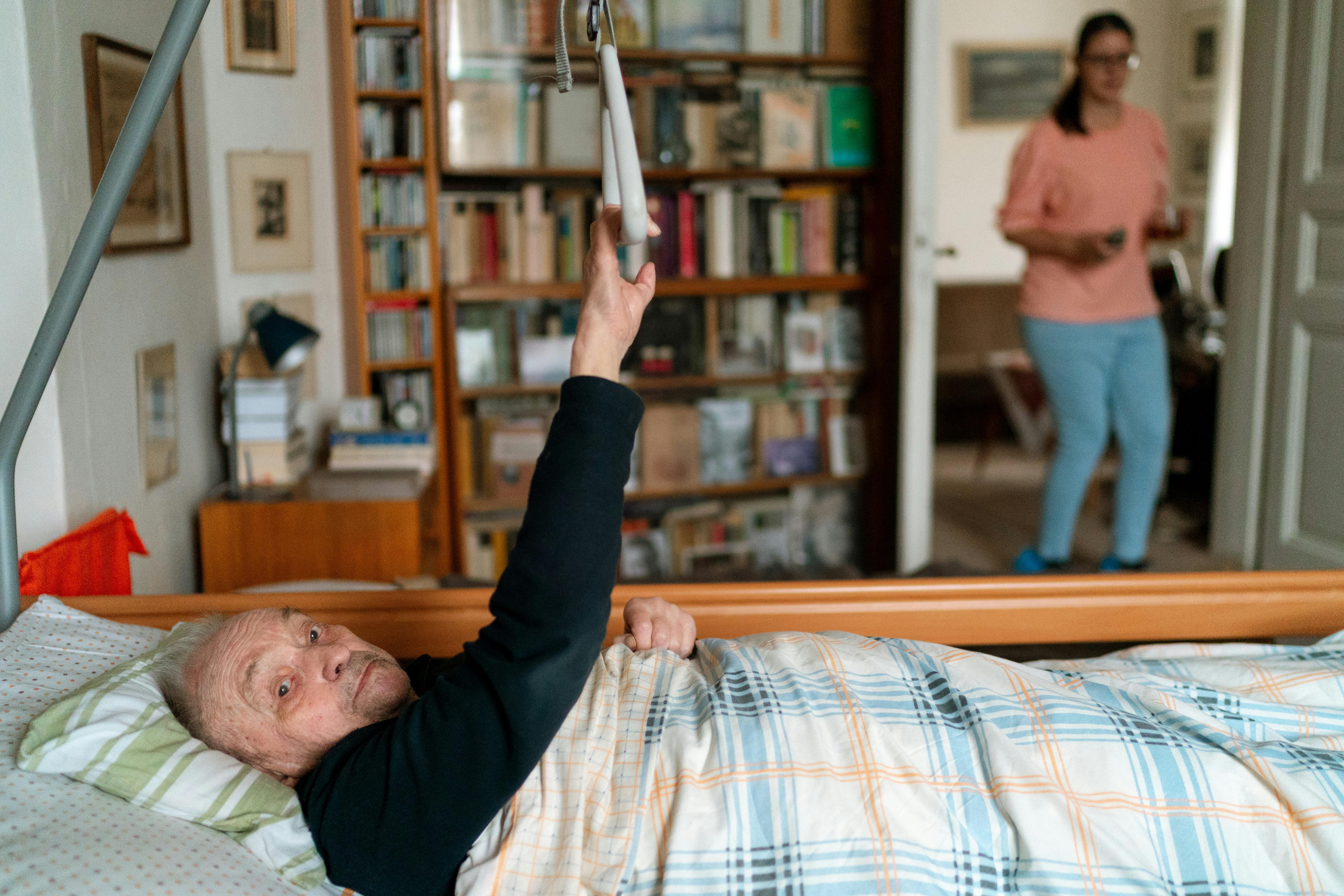 Client in bed with caregiver nearby